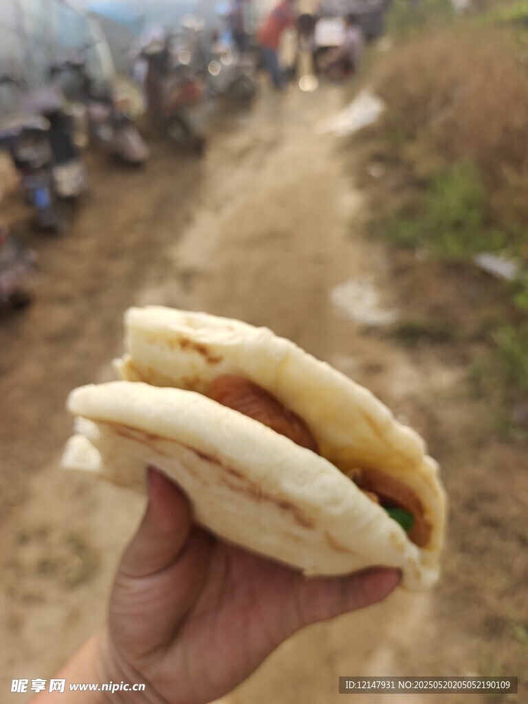 手持美味夹馍于乡间小道