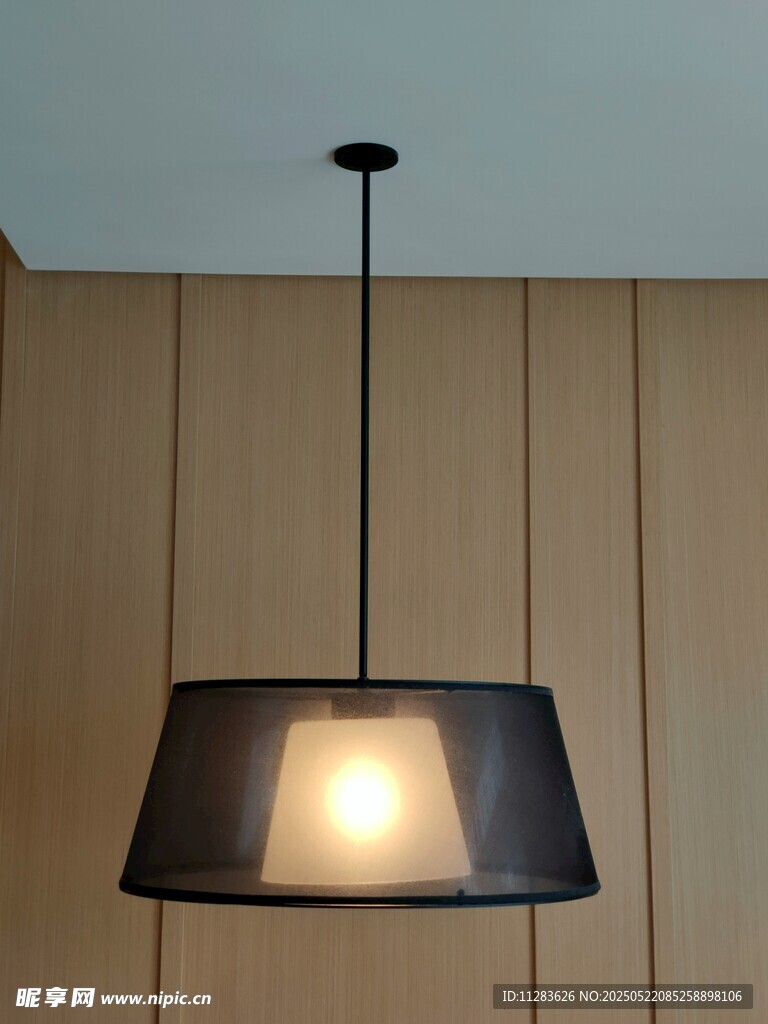 简约黑色吊灯悬挂于墙前