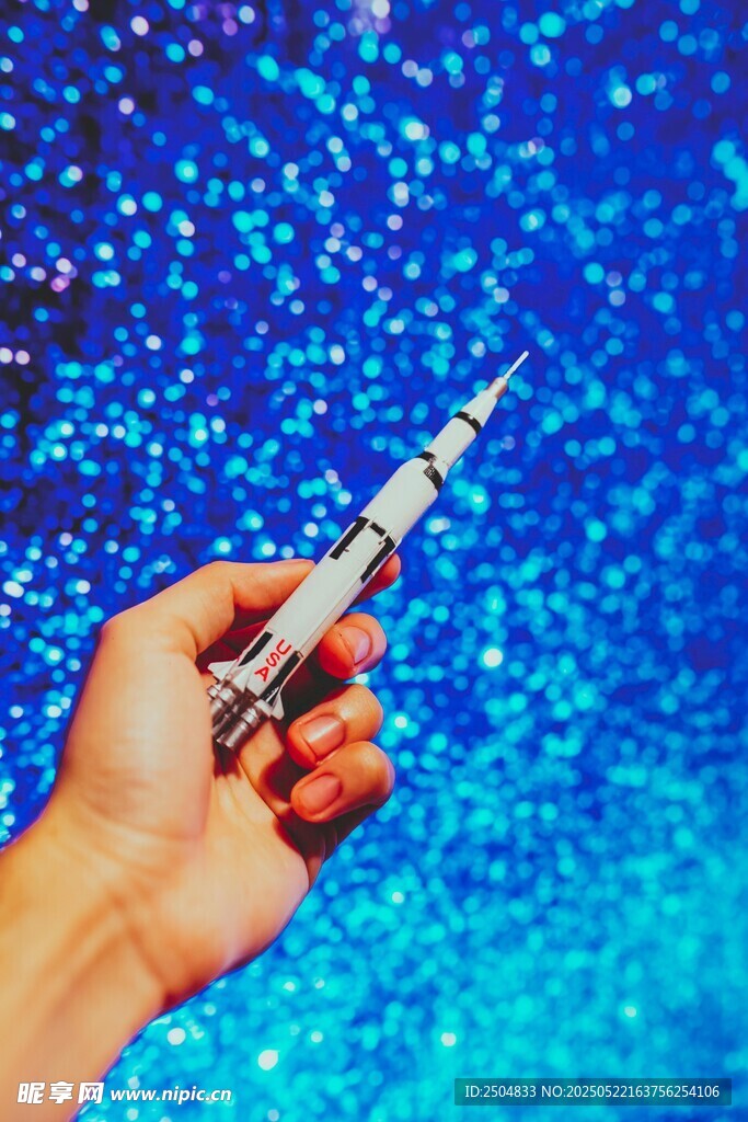 手持钢笔于梦幻蓝背景前