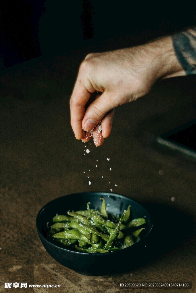 手撒调料于盘中青豆上
