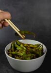 筷子夹取碗中绿色蔬菜