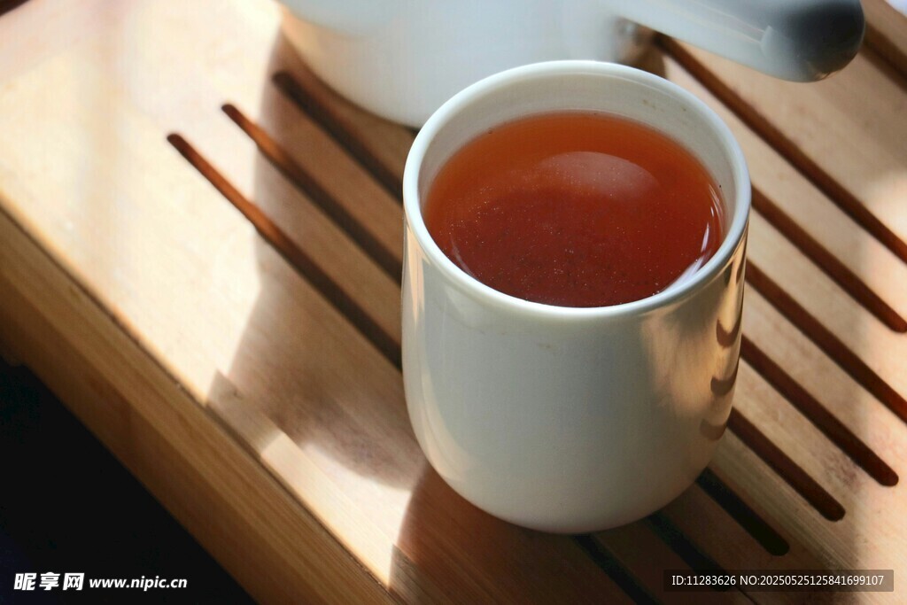 白杯盛热茶置于木托盘上