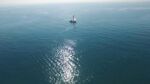 海上孤舟泛于波光海面
