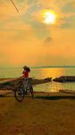 夕阳下骑行的海边身影