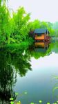 湖畔小屋映于碧水绿树间
