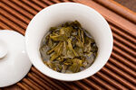白瓷杯中的鲜嫩泡开茶叶茶底