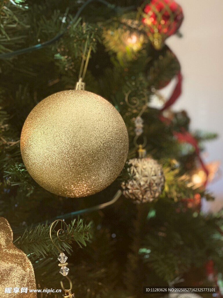 金色圣诞球挂于翠绿圣诞树