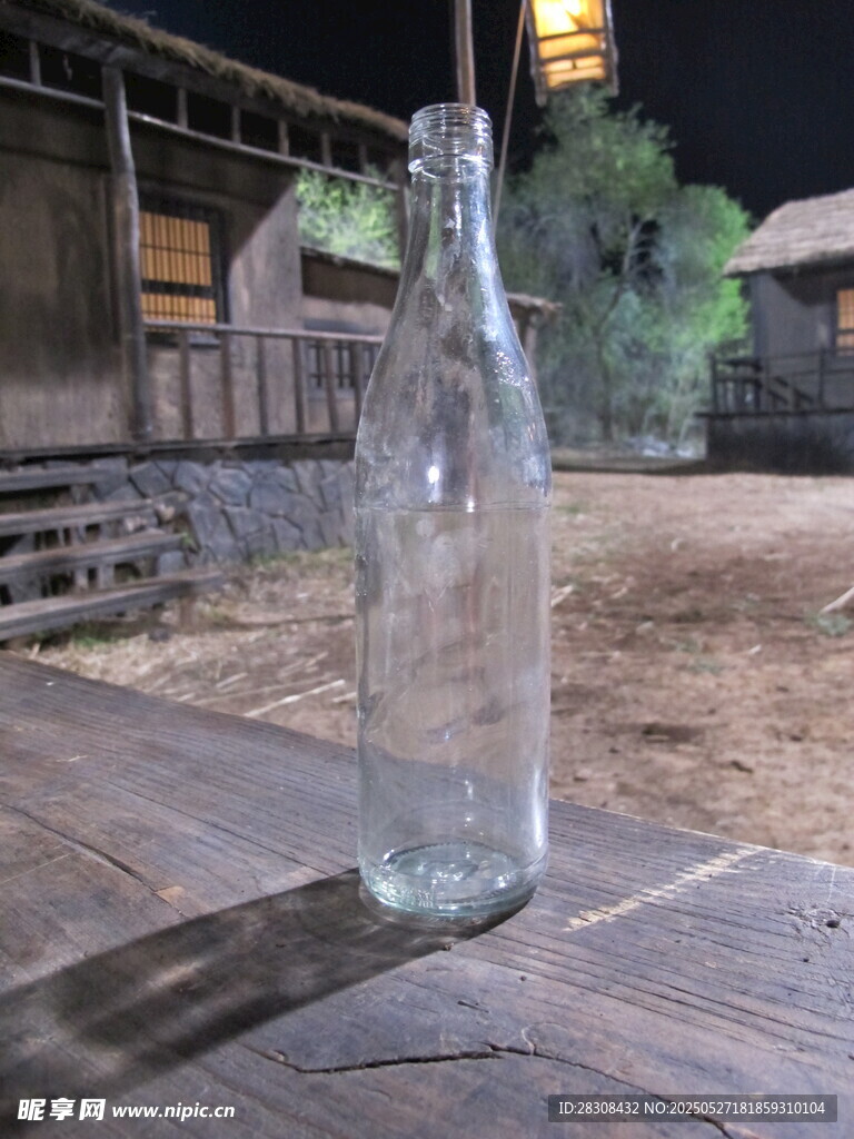 木桌上的透明空玻璃瓶