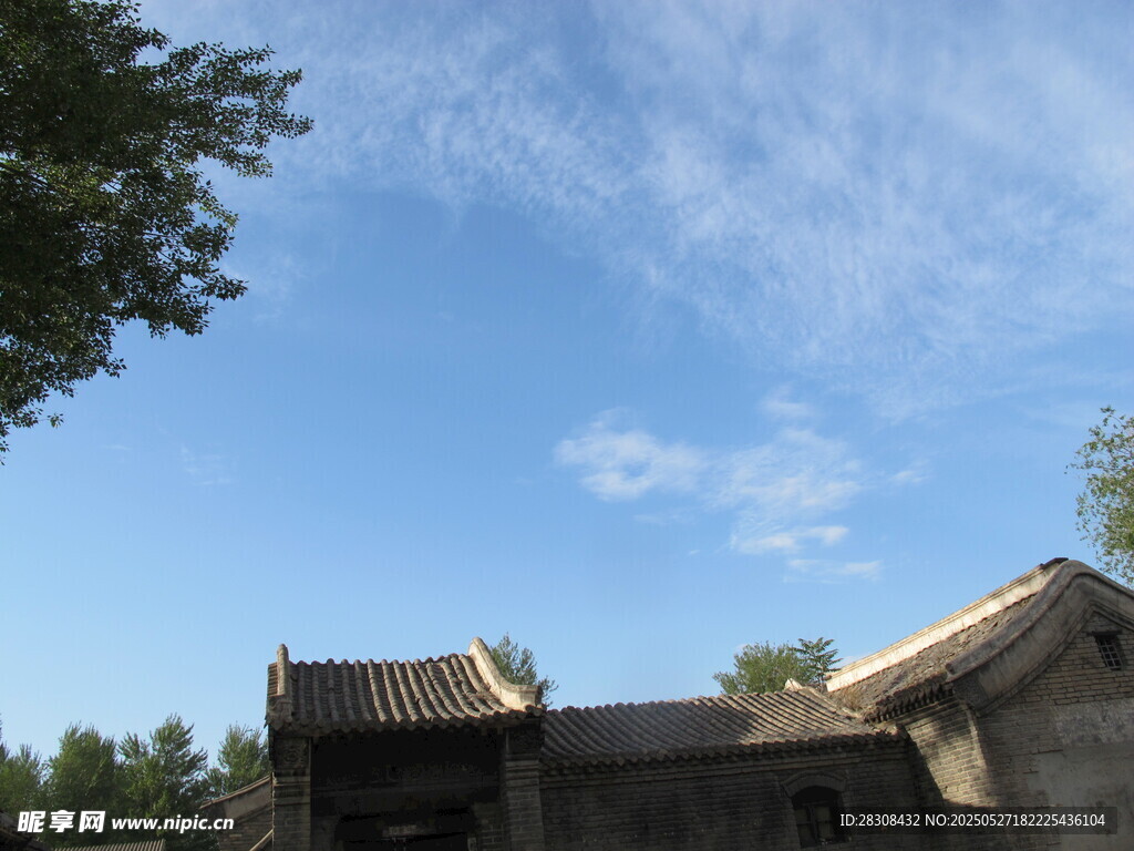 古宅蓝天绿树相映成趣