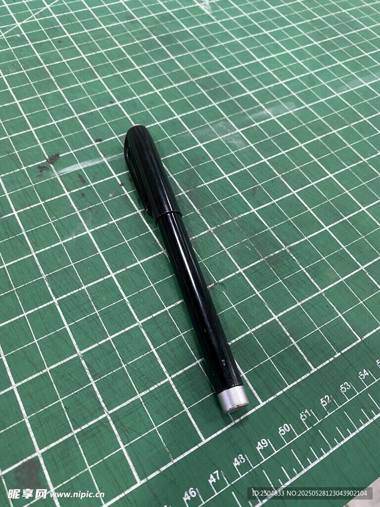 黑色雕刻刀置于绿色垫板上