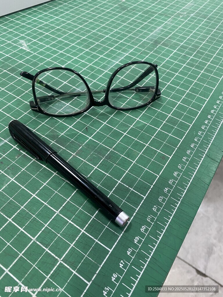 眼镜与笔置于切割垫上