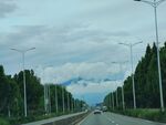 宽阔公路旁绿树与远山
