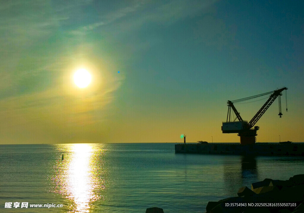 海边夕阳下的起重机