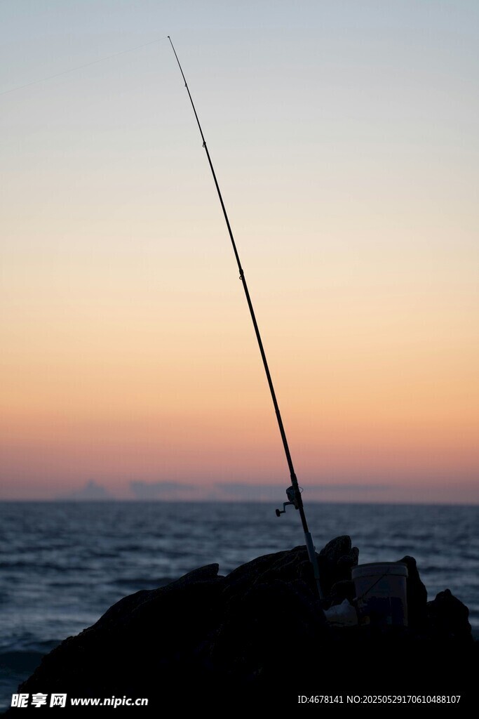 夕阳下的海边垂钓