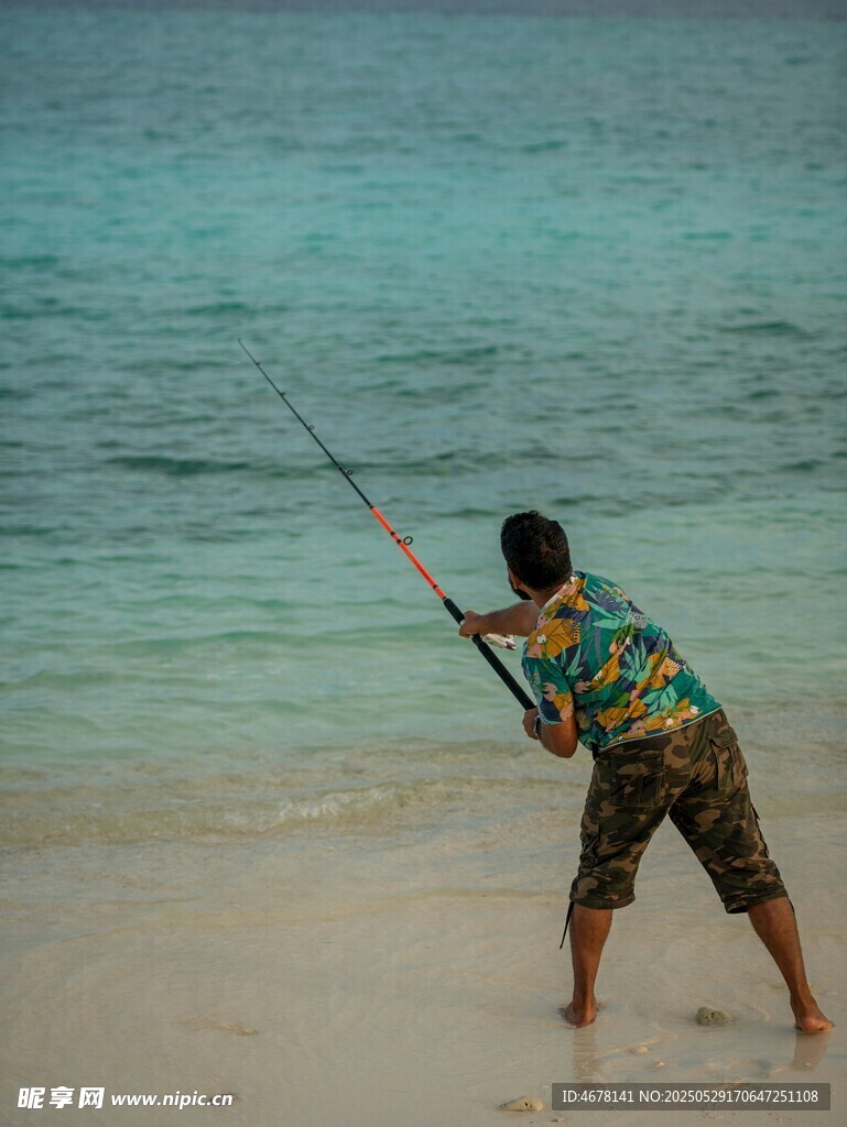 海滩上男子专注钓鱼瞬间