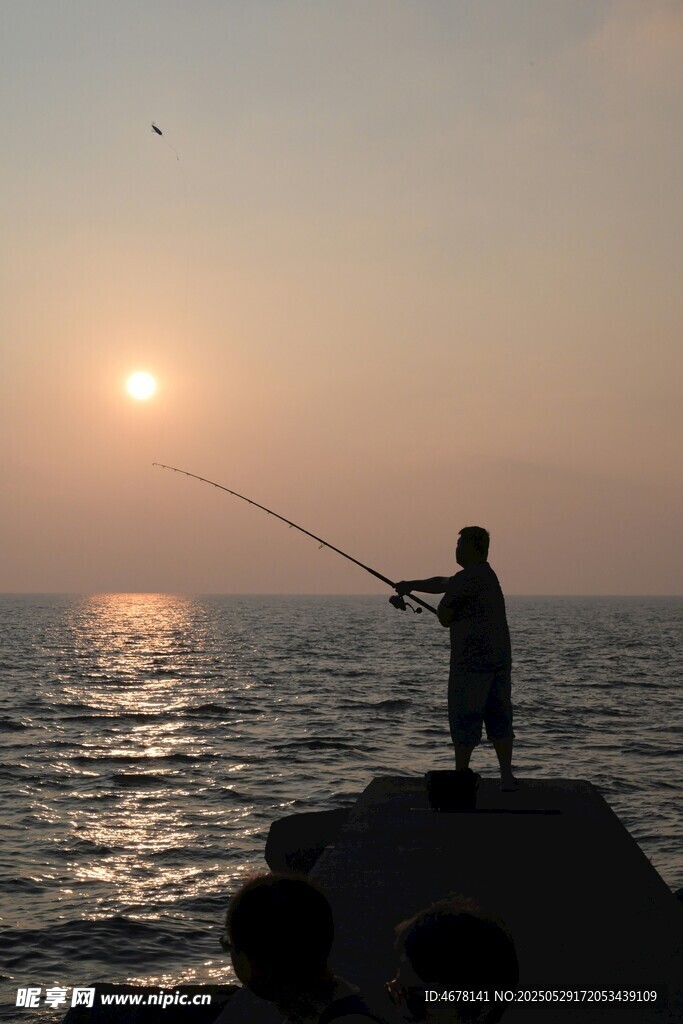 夕阳下的海边垂钓者