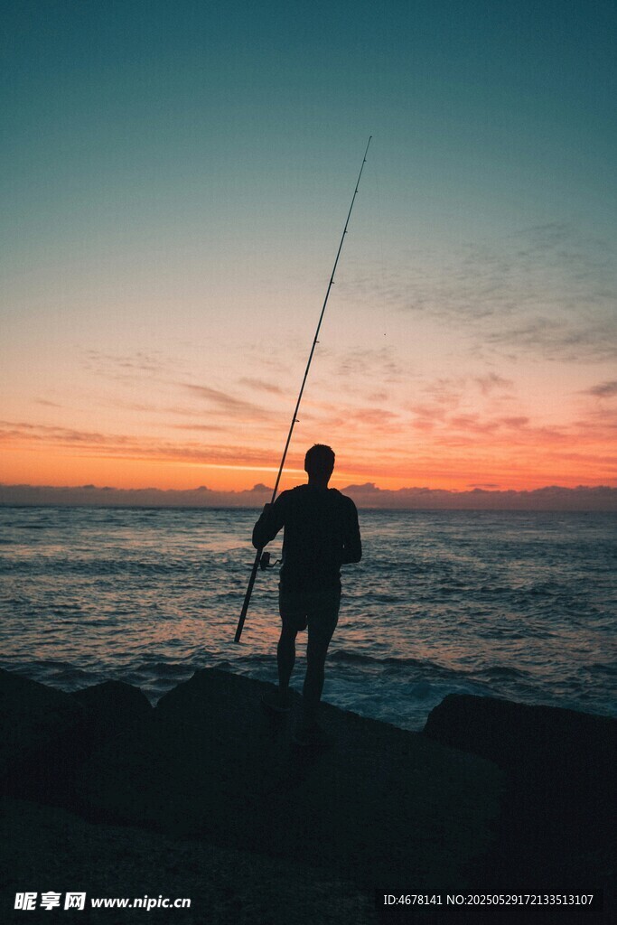 夕阳下的海边垂钓者