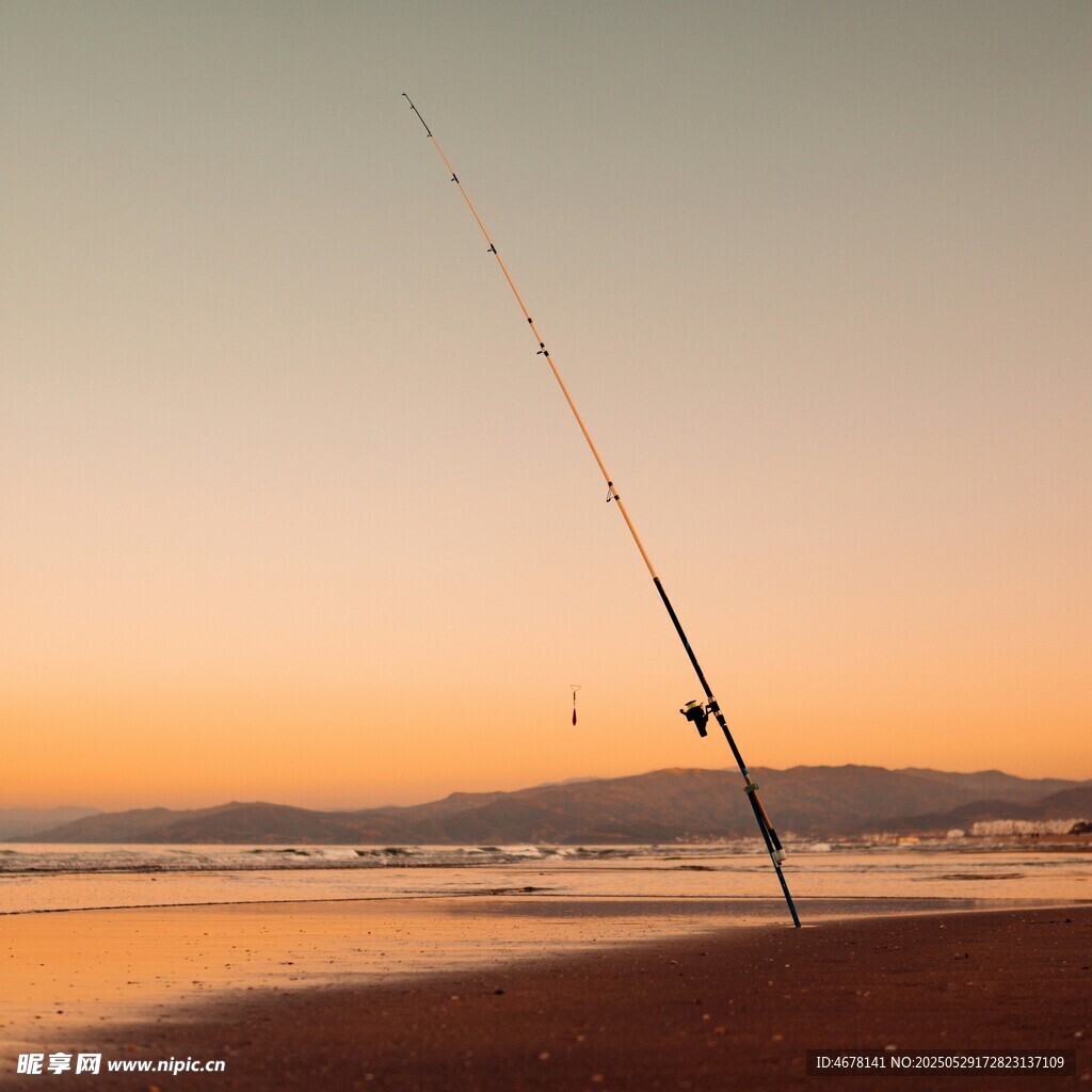 夕阳下海滩上的钓鱼竿