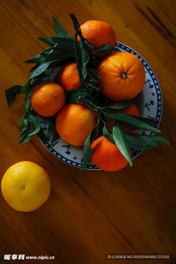 木桌上盘装带叶新鲜柑橘