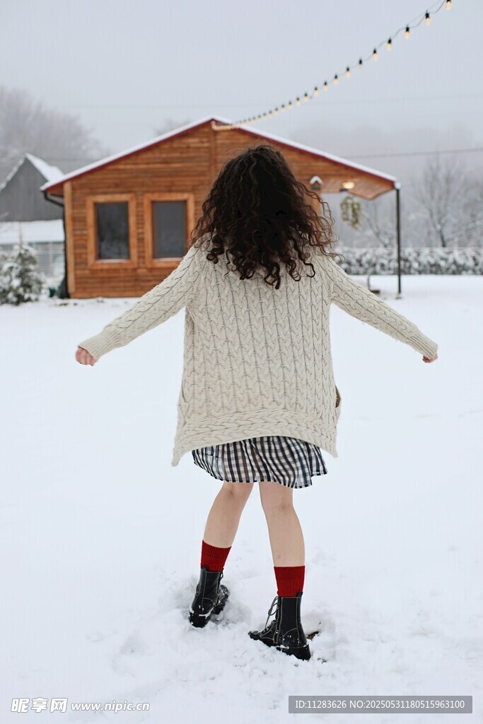 雪地中女孩张开双臂背影