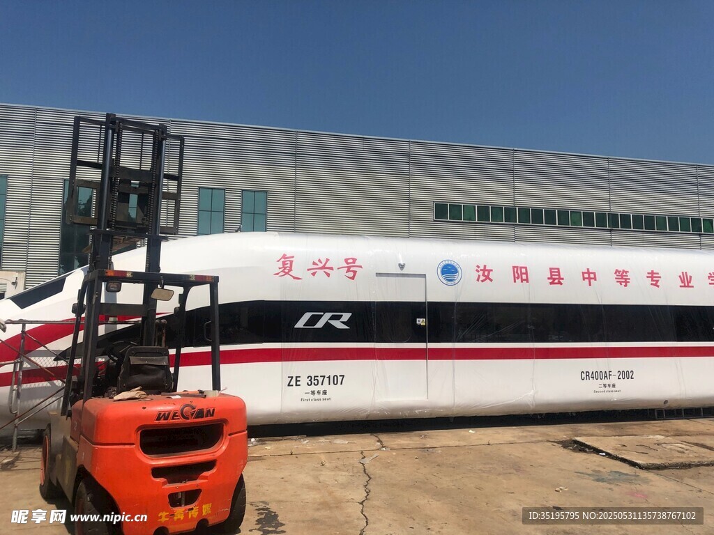 橙色叉车旁的高速列车