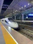 夜间高铁站台上的飞驰高铁