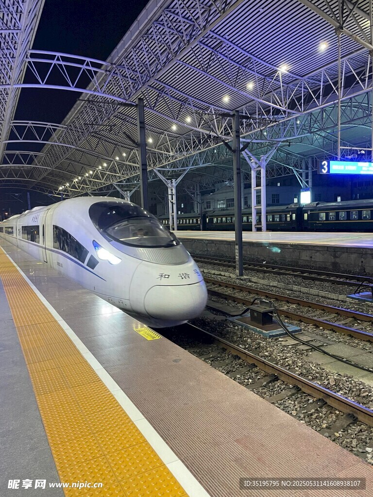 夜间高铁站台上的飞驰高铁