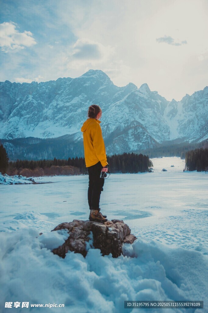 男子立于冰雪天地赏景