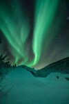 极光闪耀于雪夜山林间