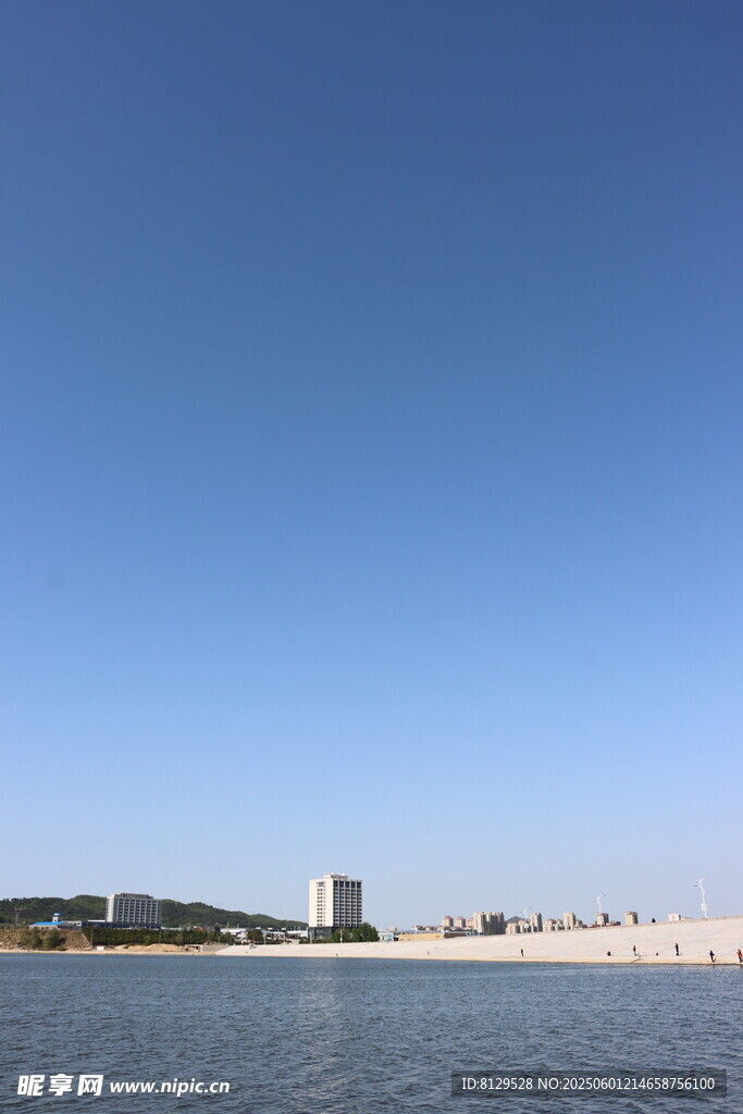 蓝天碧水旁的城市建筑景观