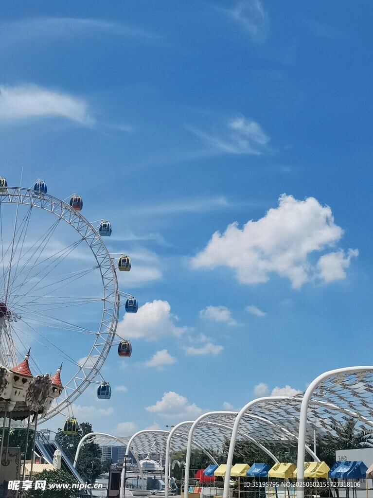 游乐园中的摩天轮与蓝天