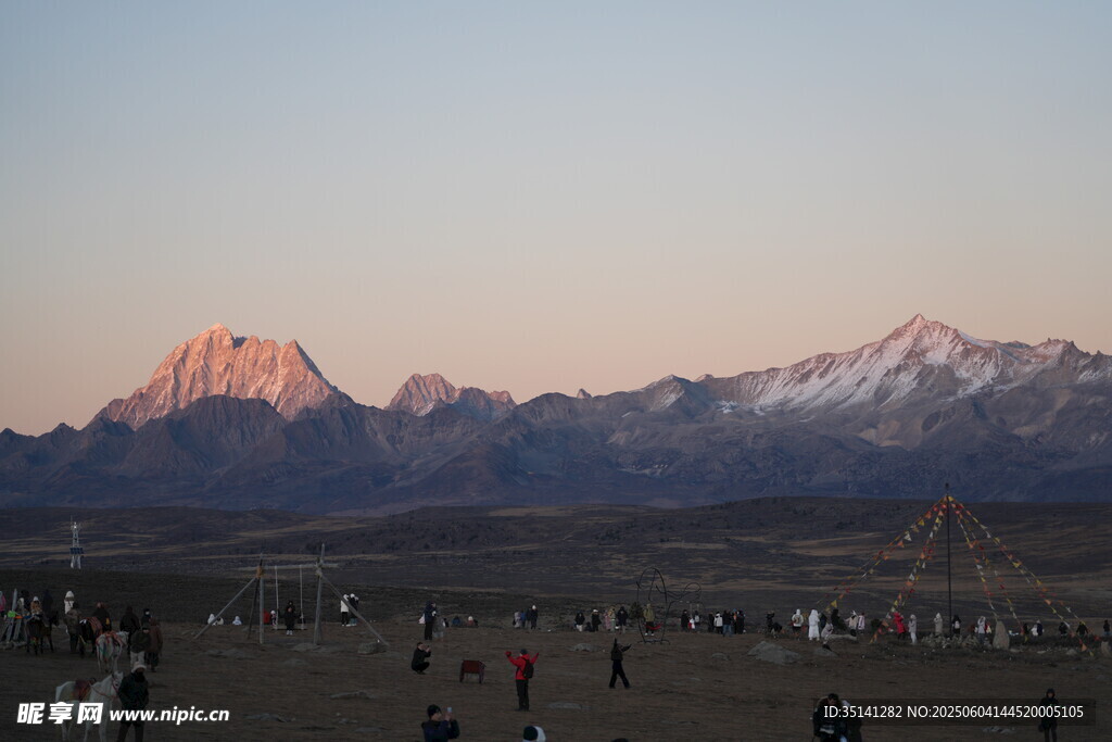 夕阳下的雪山与人群
