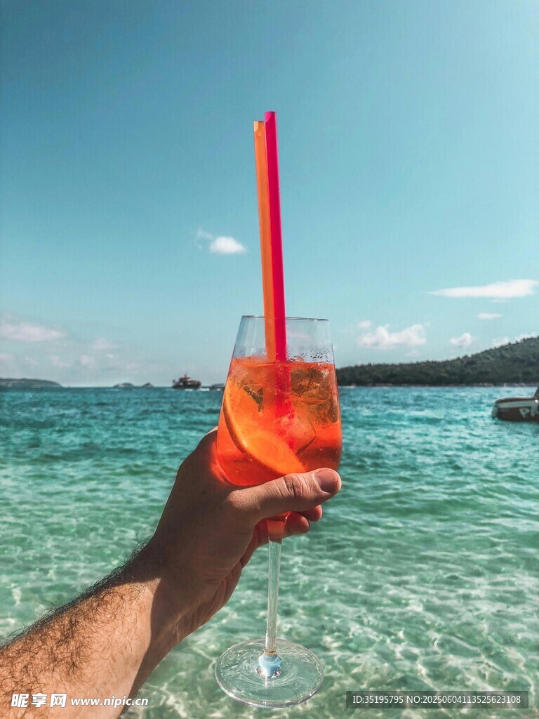 海边手持色彩缤纷的鸡尾酒
