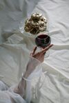 手捧饮品于柔软床榻间