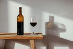 木桌上的红酒瓶与酒杯