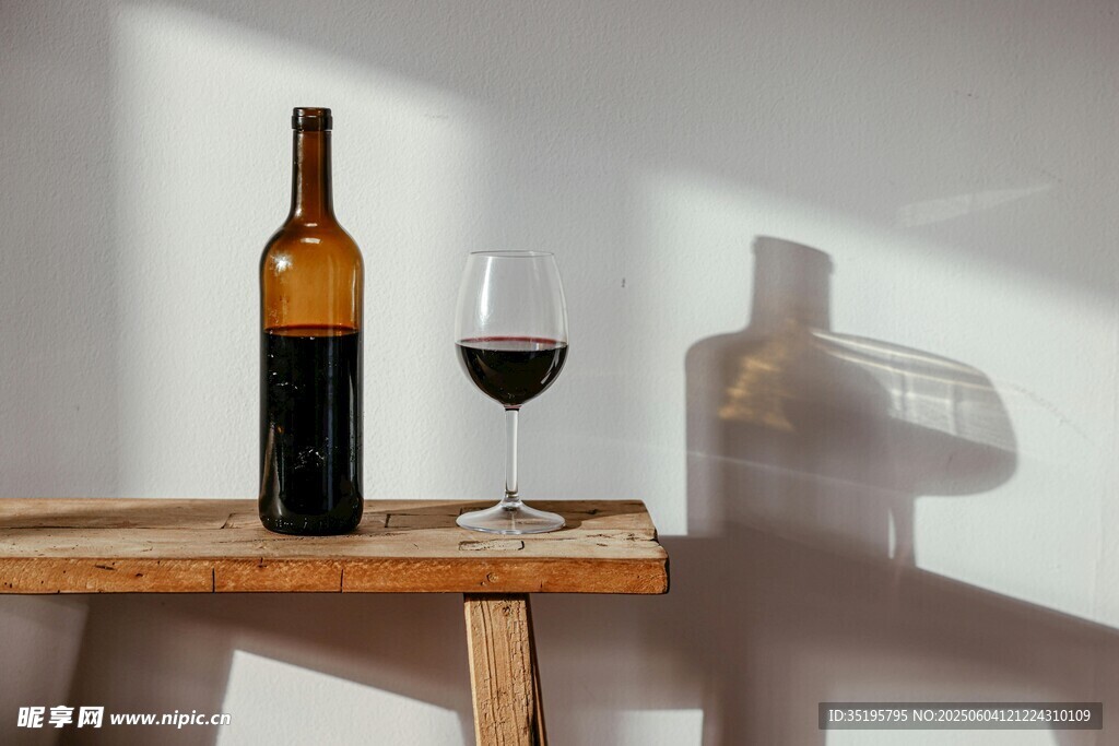 木桌上的红酒瓶与酒杯