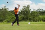男子挥杆打高尔夫球