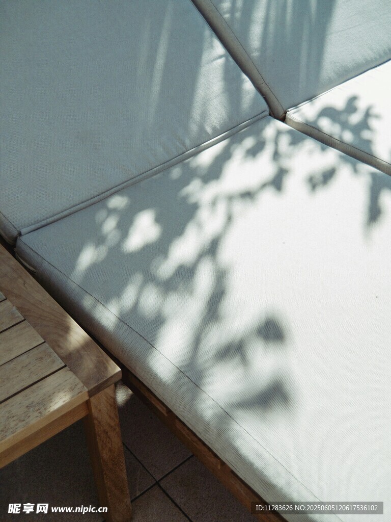 阳光下的露台躺椅与树影