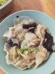 美味馄饨摆于浅蓝色碗中