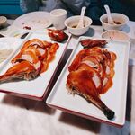 两盘美味烤鸭摆于桌前