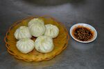 竹篮中的美味包子与蘸料