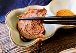 筷子夹着盘中美味牛肉