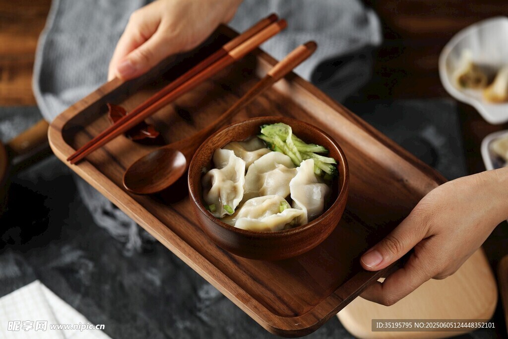手持木盘端着美味饺子