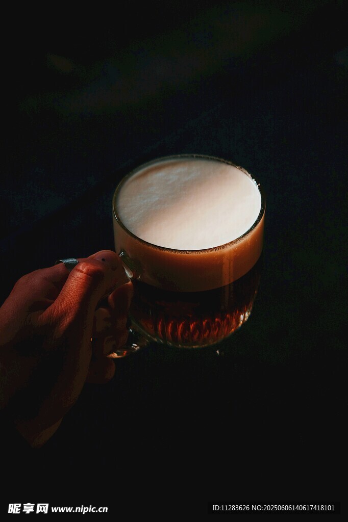手持泡沫丰富的啤酒杯