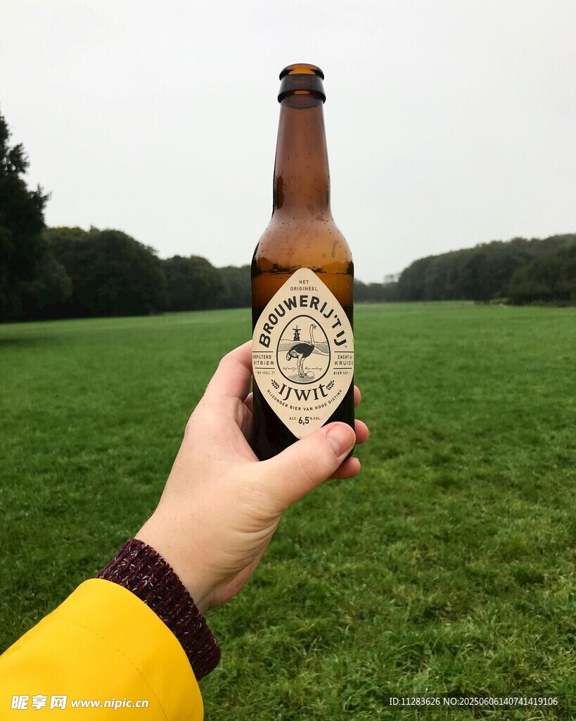 户外手持啤酒瓶惬意瞬间