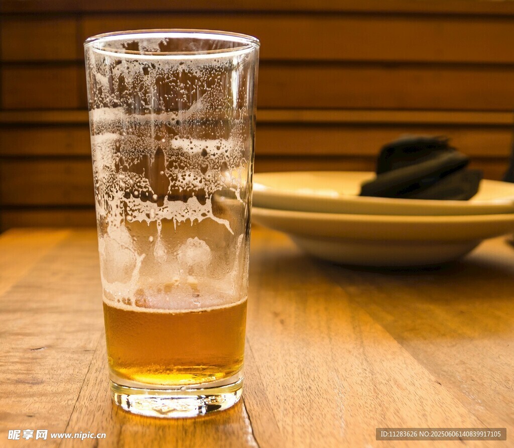 木桌上的一杯泡沫啤酒