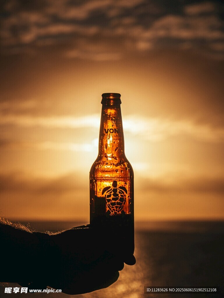 夕阳下手持啤酒瓶瞬间