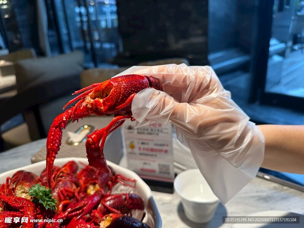 手戴手套持美味小龙虾