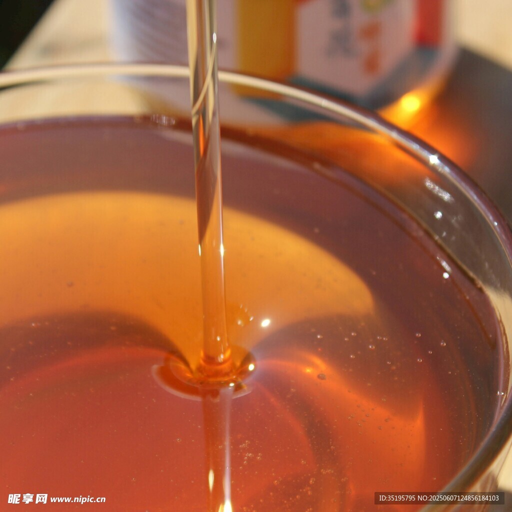 蜂蜜缓缓倒入透明容器中