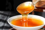 蜂蜜从勺中倾入白瓷碗